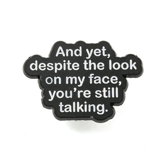 'And yet, despite the look on my face, you're still talking' enamel pin